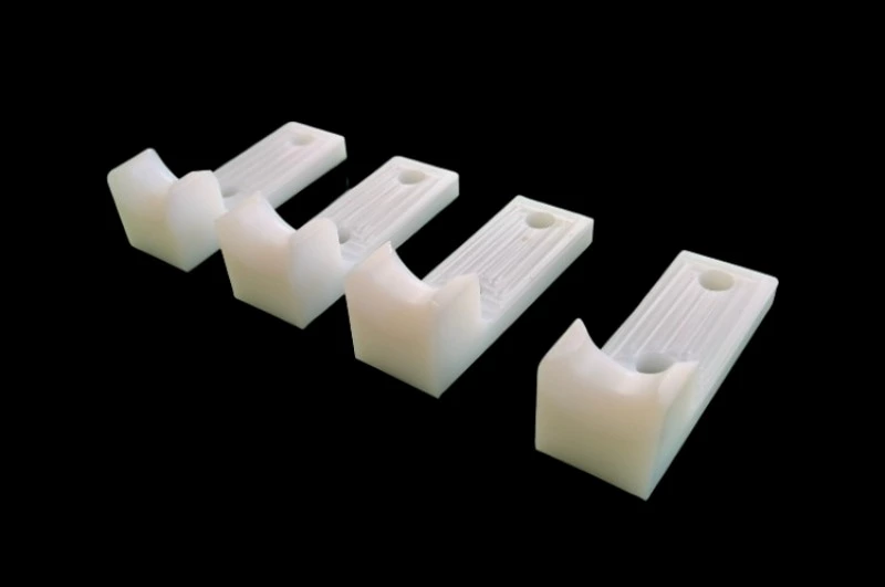 White semi-flexible UHMWPE bracket showing material flexibility and texture